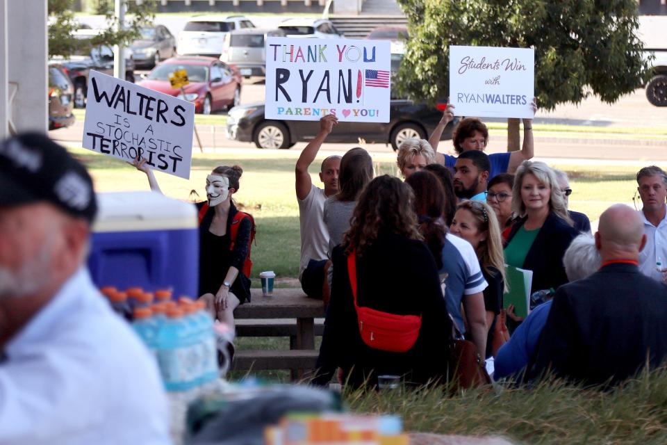 People holds signs outside the Oklahoma State Department of Education building before an Oklahoma State Board of Education meeting, Thursday, Aug. 24, 2023.