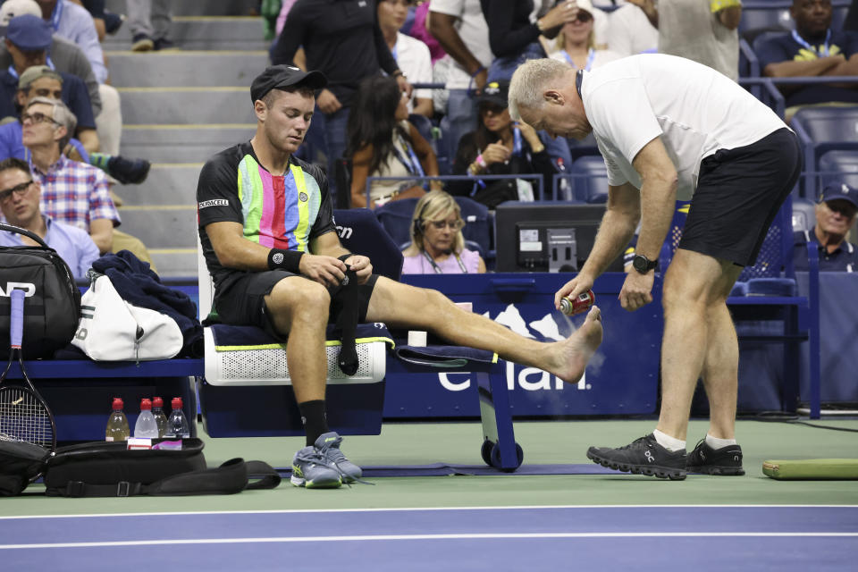 Dominik Koepfer, of Germany, is attended to during a match against Carlos Alcaraz, of Spain, at the first round of the U.S. Open tennis championships, Tuesday, Aug. 29, 2023, in New York. (AP Photo/Jason DeCrow)