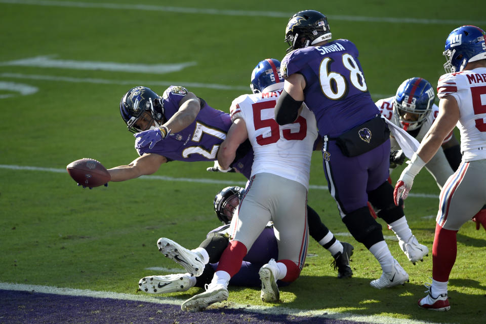 Baltimore Ravens running back J.K. Dobbins (27) dives across the goal line while scoring a touchdown on a run as New York Giants outside linebacker David Mayo (55) tries to stop him during the first half of an NFL football game, Sunday, Dec. 27, 2020, in Baltimore. (AP Photo/Gail Burton)