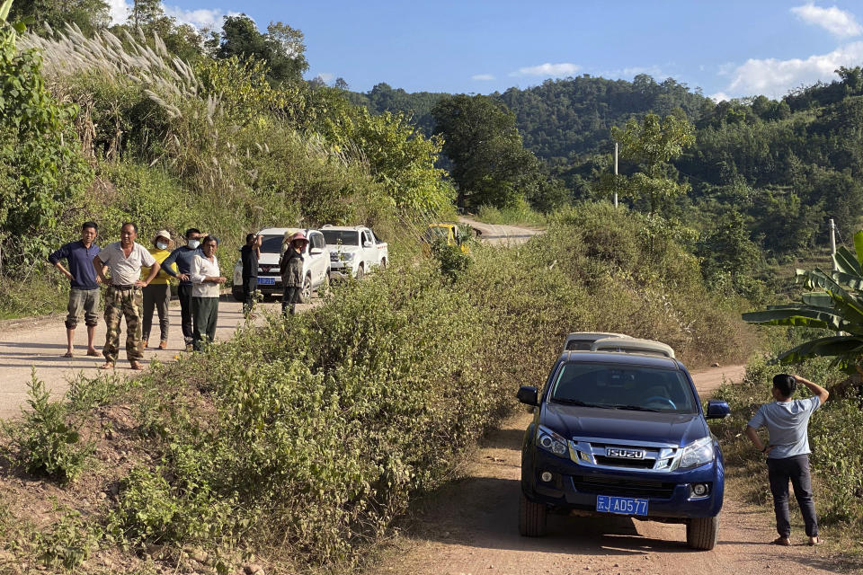 A group claiming to be local villagers use vehicles to block the roads leading to a mineshaft near Danaoshan in southern China's Yunnan province on Tuesday, Dec. 1, 2020. The mine shaft once harbored bats infected with the closest known relative of the COVID-19 virus. (AP Photo/Ng Han Guan)