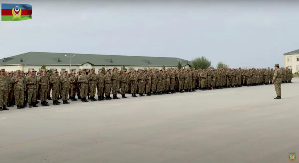 In this handout photo taken from video released by Azerbaijan's Defense Ministry on Saturday, Oct. 3, 2020, Azerbaijan's solders stand in a formation in a military base during fighting with forces of the self-proclaimed Republic of Nagorno-Karabakh, Azerbaijan. Armenia and Azerbaijan on Saturday said heavy fighting is continuing in their conflict over the separatist territory of Nagorno-Karabakh. Azerbaijan's president criticized the international mediators who have tried for decades to resolve the dispute.(Azerbaijan's Defense Ministry via AP)