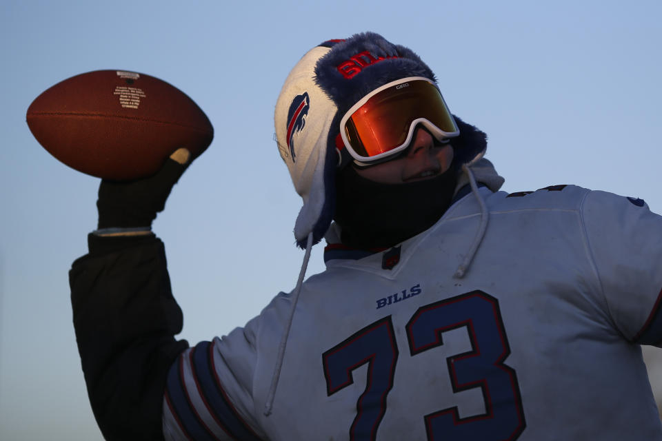 Fans tailgate as temperatures drop in the parking lots outside of Highmark Stadium before an NFL wild-card playoff football game between the Buffalo Bills and the New England Patriots, Saturday, Jan. 15, 2022, in Orchard Park, N.Y. (AP Photo/Joshua Bessex)