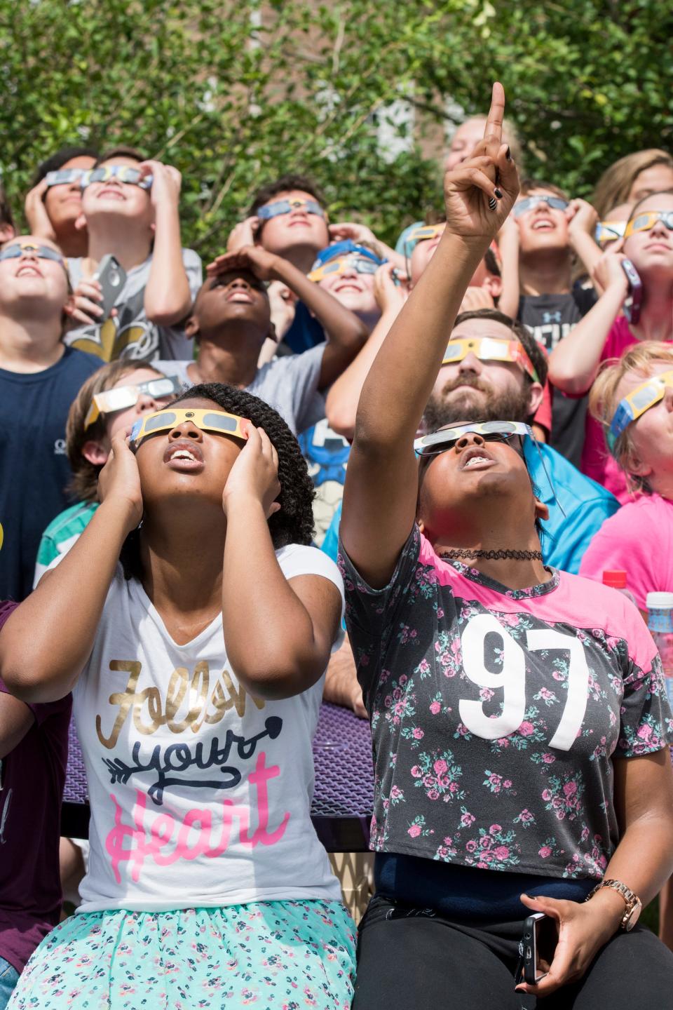 Anna Martin, bottom right, and fellow Brown-Barge Middle School students watch the solar eclipse at the West Florida Public Library on Spring Street in Pensacola on Monday, August 21, 2017.