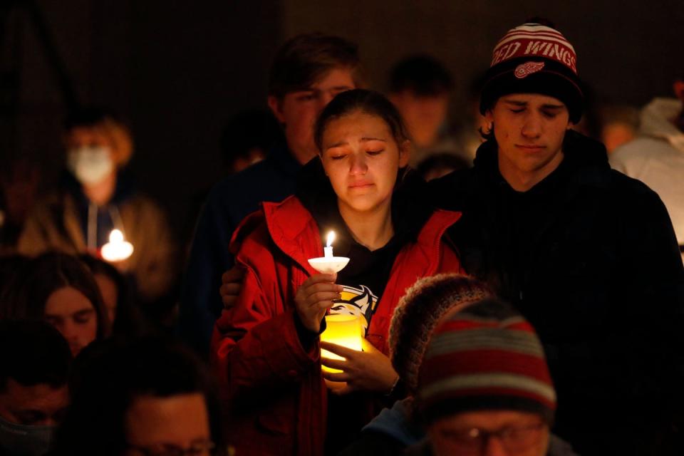 Estudiantes de Oxford High sosteniendo velas se muestran conmovidos durante una vigilia después de un tiroteo en Oxford High School en Lake Pointe Community Church en Lake Orion, Michigan (AFP vía Getty)