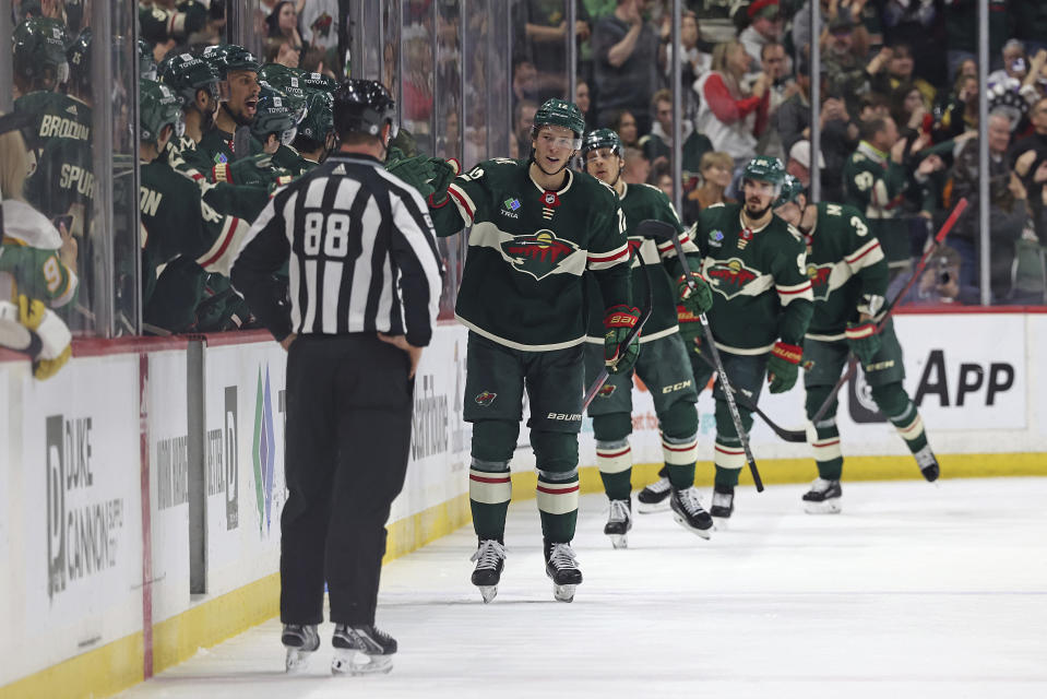 Minnesota Wild left wing Matt Boldy (12) high-fives teammates after scoring against the Vegas Golden Knights during the second period of an NHL hockey game Monday, April 3, 2023, in St. Paul, Minn. (AP Photo/Stacy Bengs)