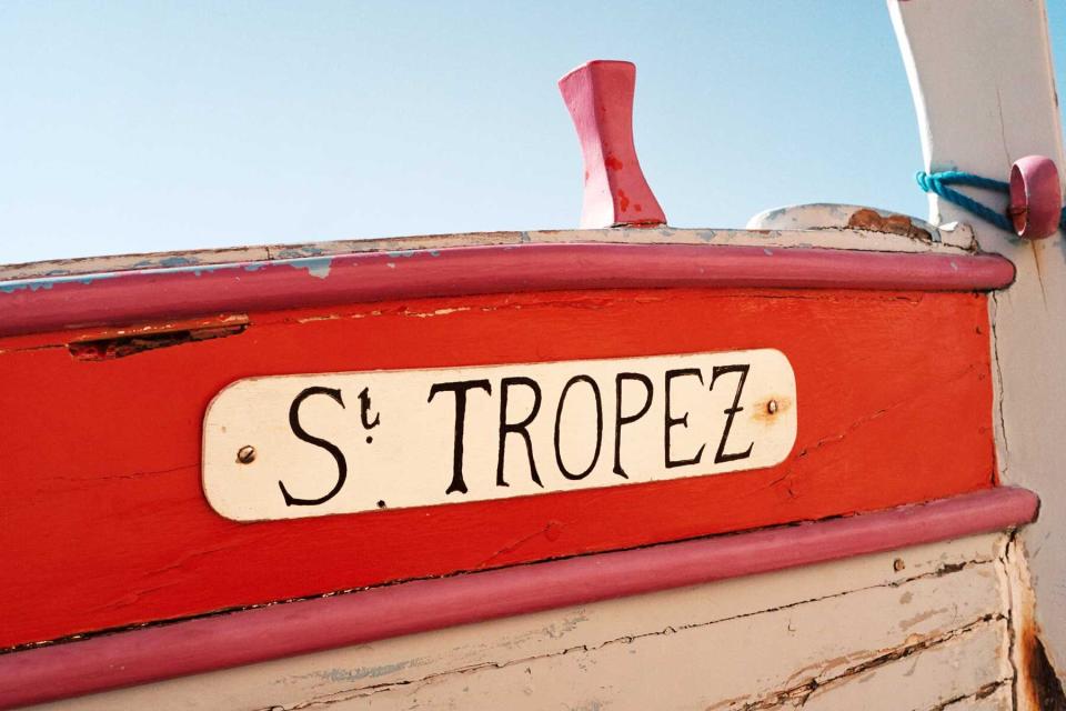 A read and white boat with St Tropez painted in black