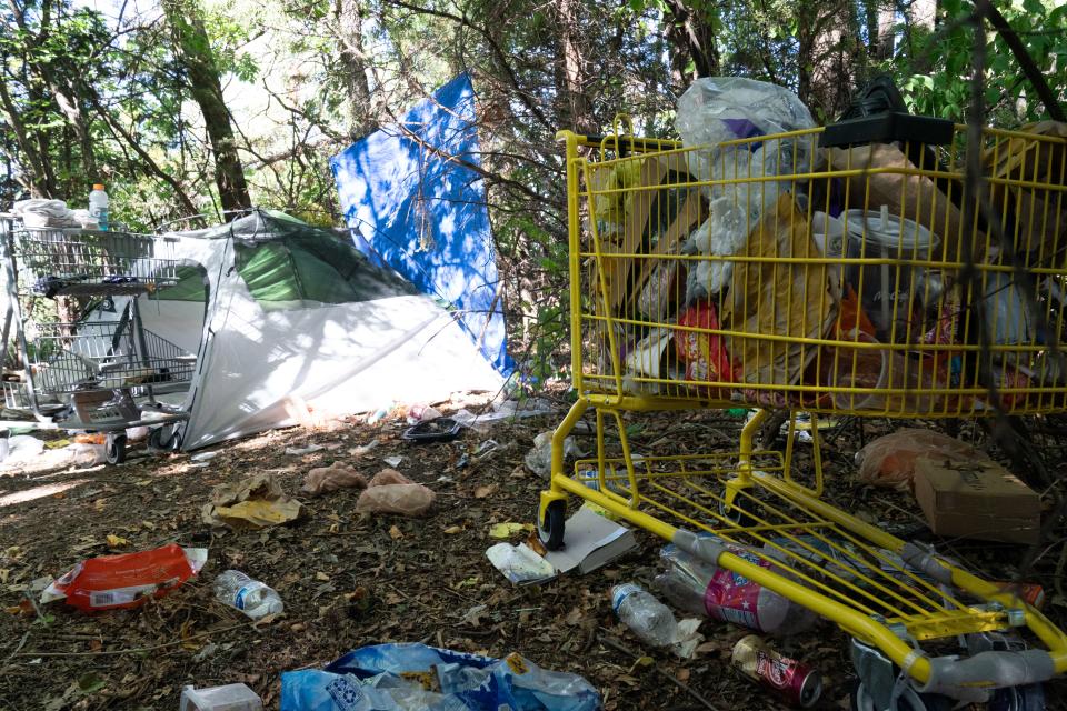 A shopping cart full of trash and fast food bags can be seen Monday at a campsite north of Dillons at 2010 S.E. 29th St.