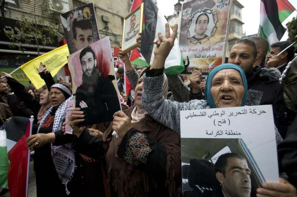 Relatives of Palestinians held in Israeli jails hold their portraits during a protest to mark "Prisoners Day" in the West Bank city of Ramallah, Wednesday, April 7, 2019.(AP Photo/Majdi Mohammed)