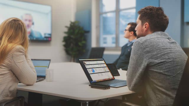  Office workers sitting at a desk with Jetbuilt and Kinly technology. . 