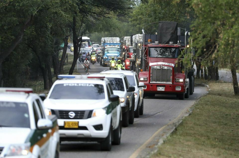 FILE - In this Feb. 16, 2019 file photo, trucks loaded with USAID humanitarian aid for Venezuela are escorted by police as they arrive at the Tienditas International Bridge in Cucuta, Colombia, on the border with Venezuela. President Nicolas Maduro is vowing to block the aid from entering Venezuela, saying the effort is part of a U.S.-led coup attempt. (AP Photo/Fernando Vergara)