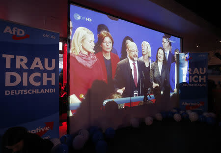 Social Democratic Party (SPD) leader and top candidate Martin Schulz is seen on a screen next to banners of the anti-immigration party Alternative fuer Deutschland (AfD) that read "I dare you Germany!" after first exit polls in the German general election (Bundestagswahl) in Berlin, Germany, September 24, 2017. REUTERS/Wolfgang Rattay