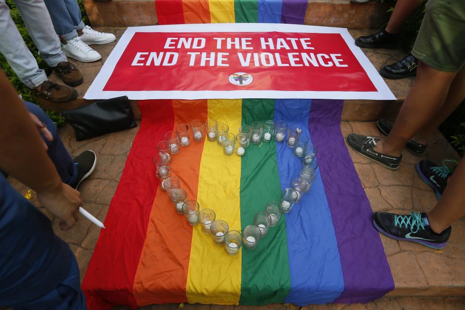FILE - In this June 14, 2016, file photo, Filipino members of the LGBQT community stand around a rainbow flag with a heart-shaped symbol during a vigil to pay tribute to the victims of the Orlando, Fla. mass shooting at the University of the Philippines campus in suburban Quezon city northeast of Manila, Philippines. The first study of its kind has found that people who are gay, lesbian, bisexual, transgender, queer or gender non-confirming are nearly four times as likely to be victims of violent crime than those outside such communities. Although other research has long shown that LGBQT people and gender minorities are disproportionately affected by crime, the study published in Science Advances on Friday, Oct. 2, 2020, looked at data that has only been collected since 2016, making for the first comprehensive and national study to examine the issue. (AP Photo/Bullit Marquez, File)