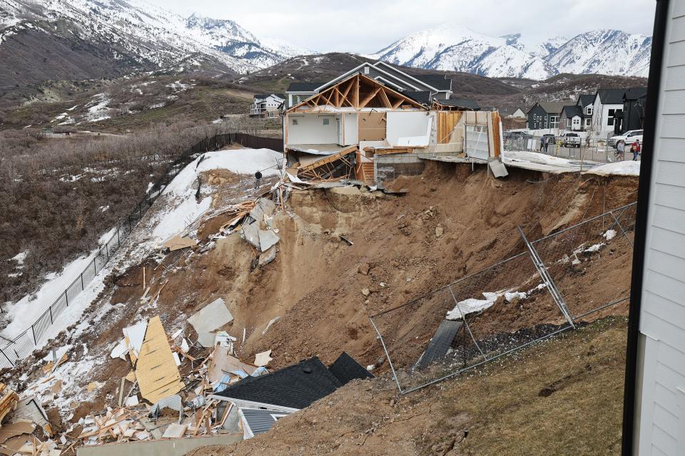 The debris of two homes in Draper sit at the bottom of a hill after sliding.