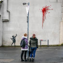 L'ultima creazione dello street artist britannico sulla facciata di un edificio a Bristol, sua città natale in Inghilterra: una bambina con una fionda di fronte a un’esplosione rossa, fatta di petali e fiori di plastica, forse il cuore infranto di Cupido. (Photo by Ben Birchall/PA Images via Getty Images)