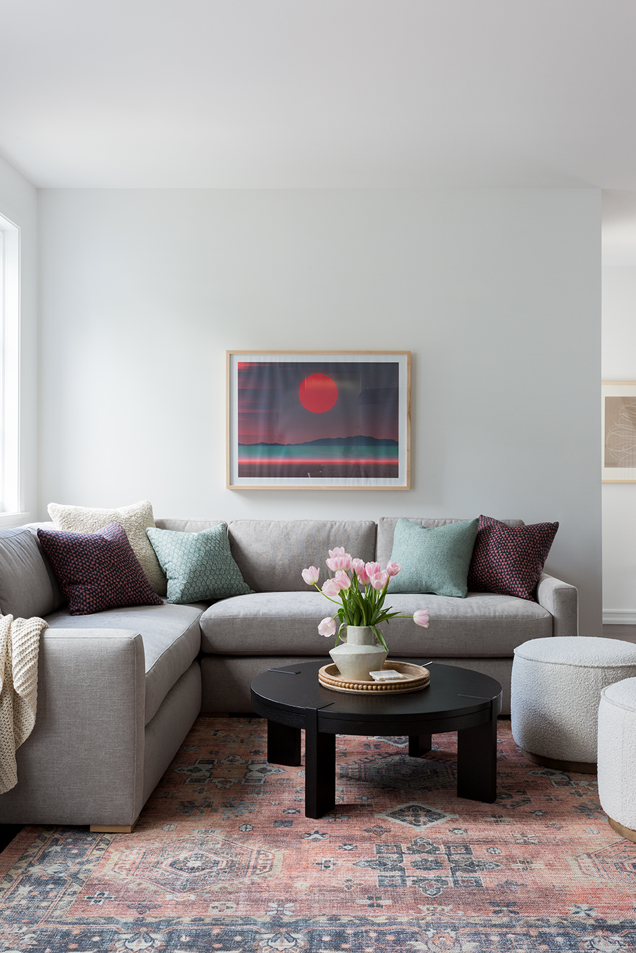 living room with gray sofa, pale pink vintage rug, and mint green throw pillows