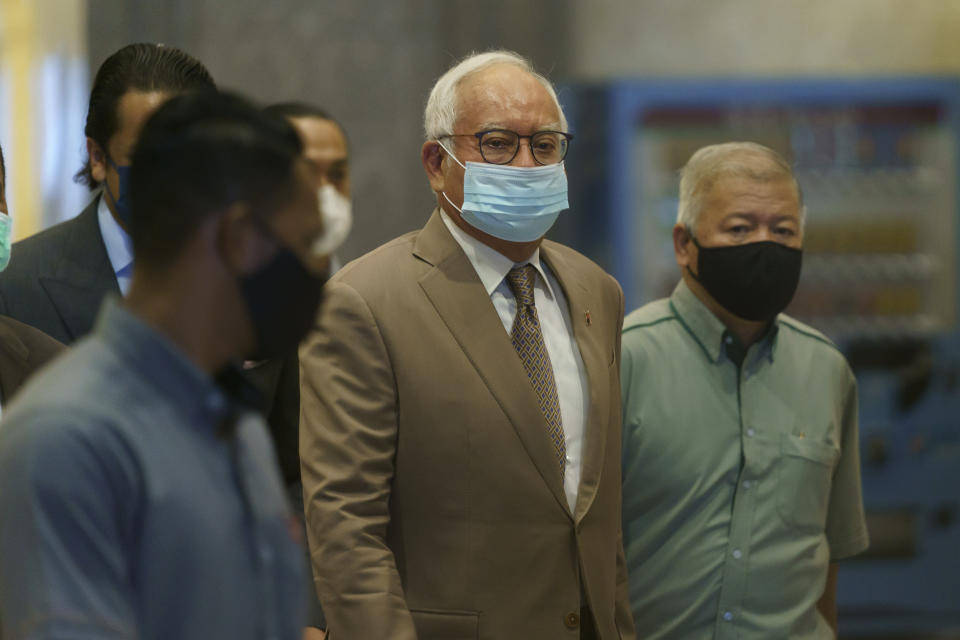 Former Malaysian Prime Minister Najib Razak, second from right, wearing a face mask arrives at Court of Appeal in Putrajaya, Malaysia, Monday, April 5, 2021. The court Monday began hearing an appeal by Najib to overturn his conviction and 12-year jail sentence linked to the massive looting of the 1MDB state investment fund that brought down his government in 2018. (AP Photo/Vincent Thian)