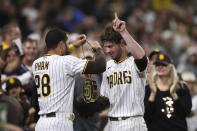 San Diego Padres' Wil Myers, right, points to the sky as Tommy Pham (28) puts the "swag chain" on him after Myers hit a home run in the fourth inning of the team's baseball game against the Cincinnati Reds Friday, June 18, 2021, in San Diego. (AP Photo/Derrick Tuskan)