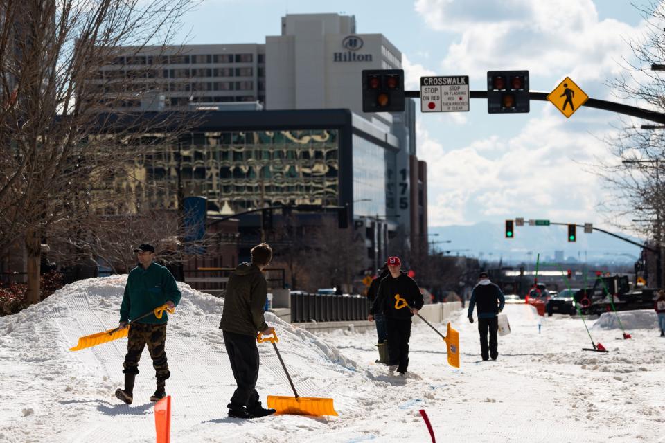 People shovel the snow before a skijoring event, part of the Salt Lake Winter Roundup, on West Temple in downtown Salt Lake City on Saturday, Feb. 10, 2024. The snow was brought from Solitude to downtown Salt Lake City for the event. | Megan Nielsen, Deseret News