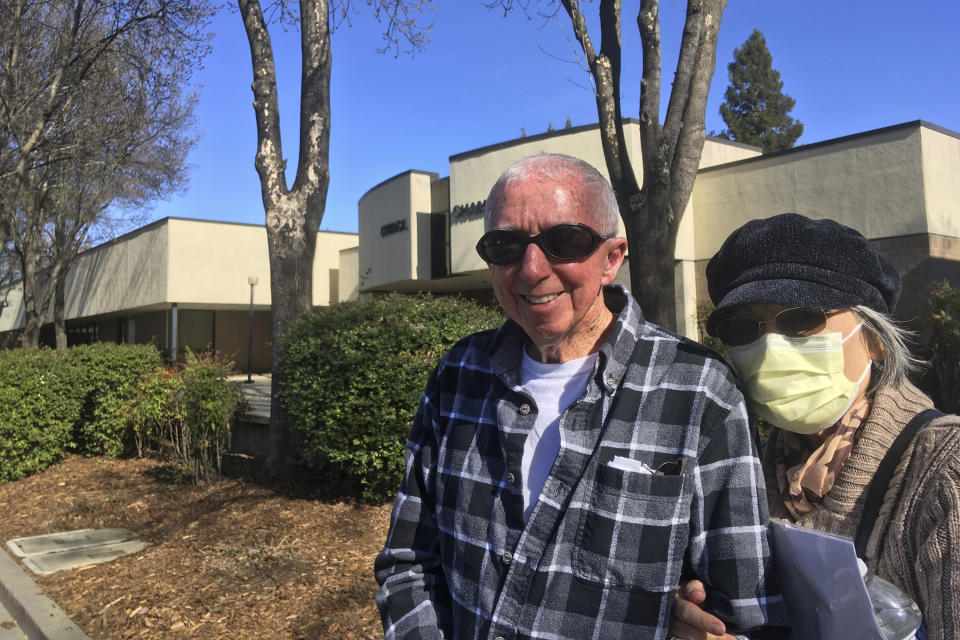 Eugenia Kendall, right, wears a mask outside of the Vacaville City Hall while standing with her husband, Ivan, Thursday, Feb. 27, 2020, in Vacaville, Calif. On Wednesday, the U.S. Centers for Disease Control and Prevention confirmed a case of coronavirus in Solano County, California. It's believed to be the first case in the U.S. of someone who has not traveled abroad or been in close contact with someone who has. Eugenia Kendall says she wears a mask because her immune system has been weakened from the chemotherapy she receives for ovarian cancer. Ivan Kendall says the they are not paranoid, just being practical. (AP Photo/Don Thompson)