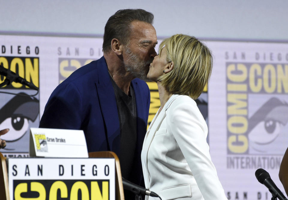 Arnold Schwarzenegger, left, and Linda Hamilton kiss at the "Terminator: Dark Fate" panel on day one of Comic-Con International on Thursday, July 18, 2019, in San Diego. (Photo by Chris Pizzello/Invision/AP)