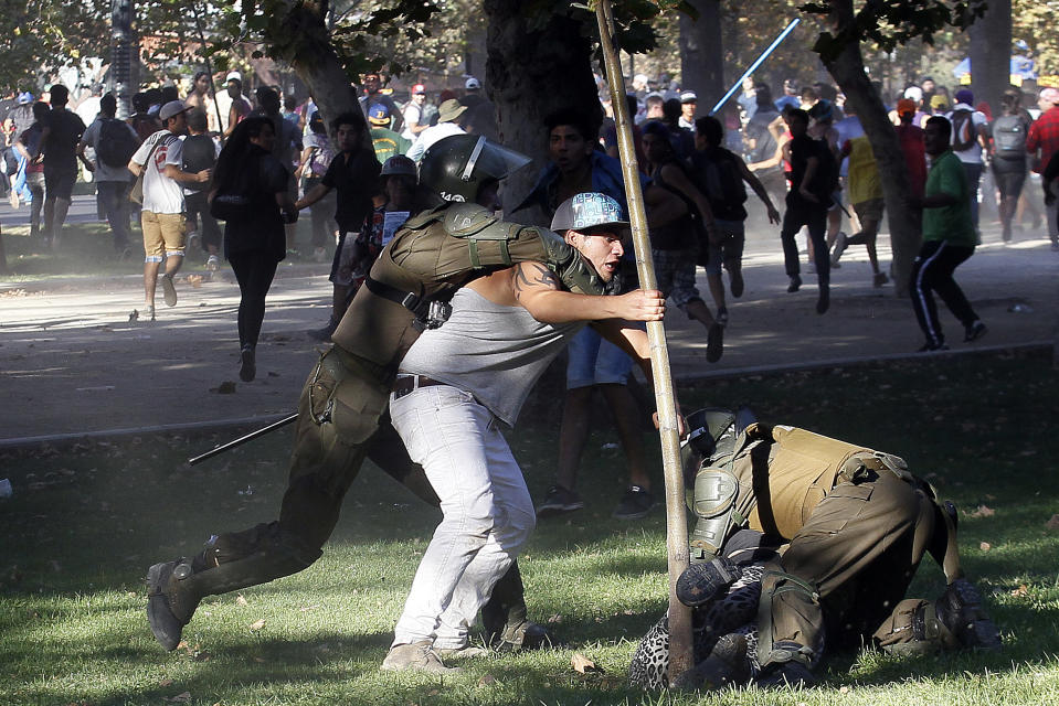 Un manifestante es detenido por la policía antimotines durante enfrentamientos violentos al concluir una marcha de protesta en el Parque Forestal, en Santiago, Chile, el sábado 22 de marzo de 2014. (Foto AP/Luis Hidalgo)