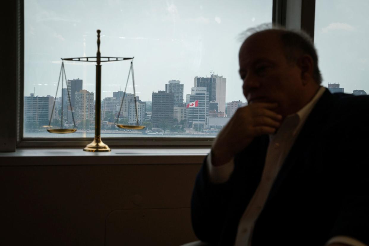 A view of the Canadian skyline is seen through a window as Detroit Mayor Mike Duggan sits for an interview with a Free Press reporter at his office in downtown Detroit on Thursday, August 10, 2023.