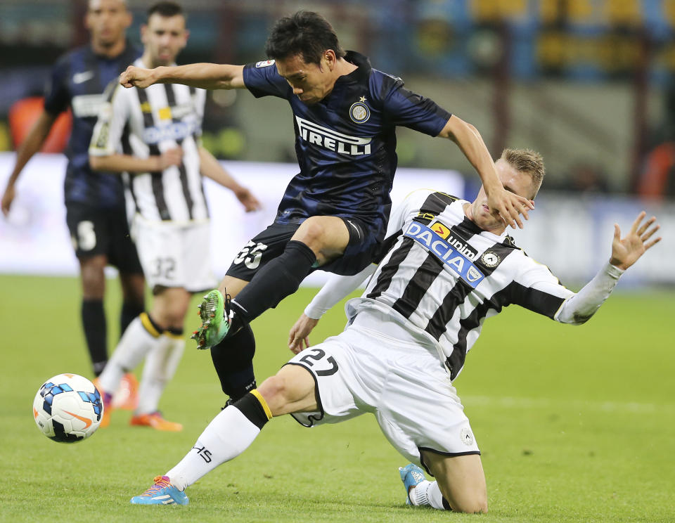 Inter Milan defender Yuto Nagatomo, left, of Japan, is tackled by Udinese defender Silvan Widmer, of Switzerland, during the Serie A soccer match between Inter Milan and Udinese at the San Siro stadium in Milan, Italy, Thursday, March 27, 2014. (AP Photo/Antonio Calanni)