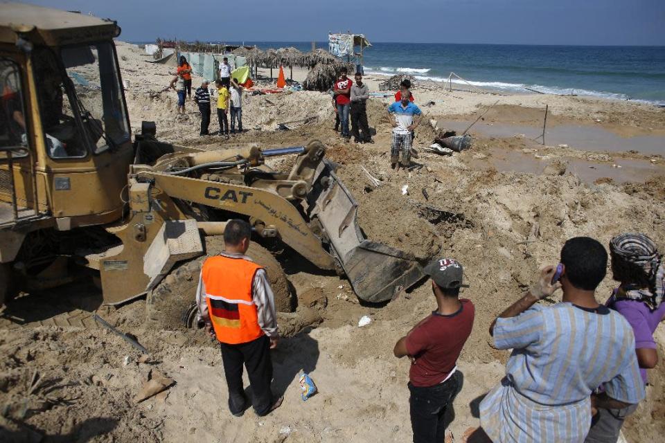 Palestinians remove debris as they search for bodies in the southern Gaza Strip on July 10, 2014 at a beach cafe hit the previous night by an Israeli air strike while people were watching the World Cup (AFP Photo/Thomas Coex)