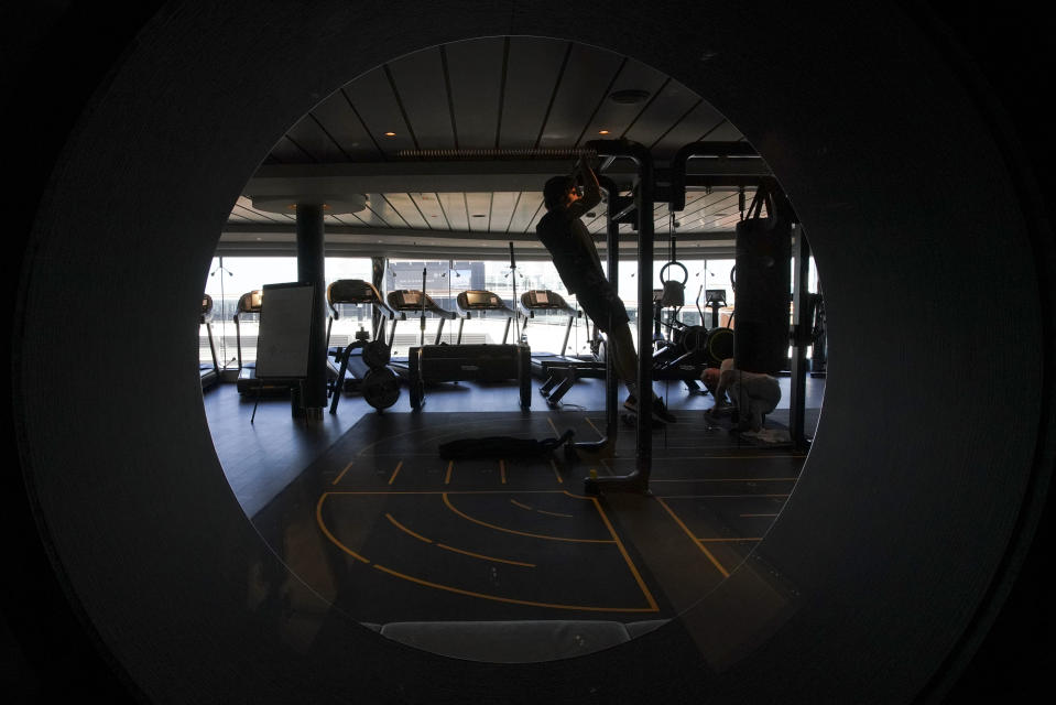 A man exercises in a gym on the MSC Grandiosa cruise ship in Civitavecchia, near Rome, Wednesday, March 31, 2021. MSC Grandiosa, the world's only cruise ship to be operating at the moment, left from Genoa on March 30 and stopped in Civitavecchia near Rome to pick up more passengers and then sail toward Naples, Cagliari, and Malta to be back in Genoa on April 6. For most of the winter, the MSC Grandiosa has been a lonely flag-bearer of the global cruise industry stalled by the pandemic, plying the Mediterranean Sea with seven-night cruises along Italy’s western coast, its major islands and a stop in Malta. (AP Photo/Andrew Medichini)