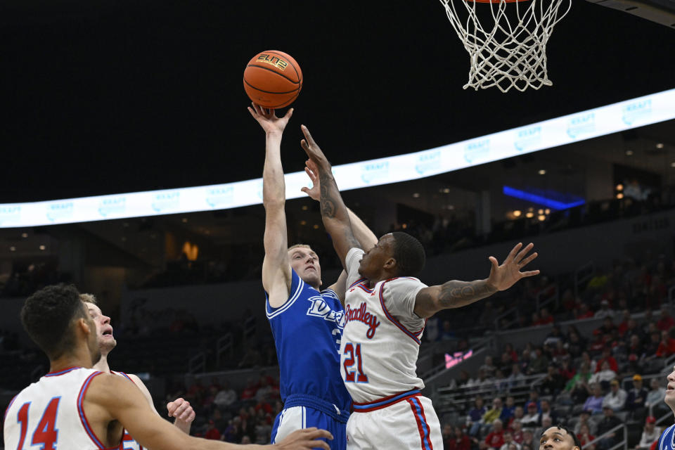 Drake guard Garrett Sturtz, center left, shoots as Bradley guard Duke Deen (21) defends during the first half of the championship game in the MVC basketball tournament, Sunday, March 5, 2023, in St. Louis. (AP Photo/Joe Puetz)