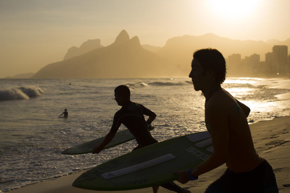 This Sept. 5, 2012 photo shows skimboarders running to the water at Ipanema beach in Rio de Janeiro, Brazil. Rio boasts some of the world's most stunning urban beaches and they're worth several visits. (AP Photo/Felipe Dana)