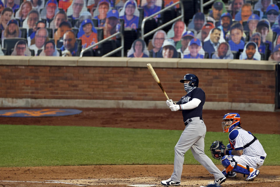 New York Yankees' Clint Frazier, left, watches his two-run home run against the New York Mets during the fourth inning of a baseball spring training game Saturday, July 18, 2020, in New York. (AP Photo/Adam Hunger)