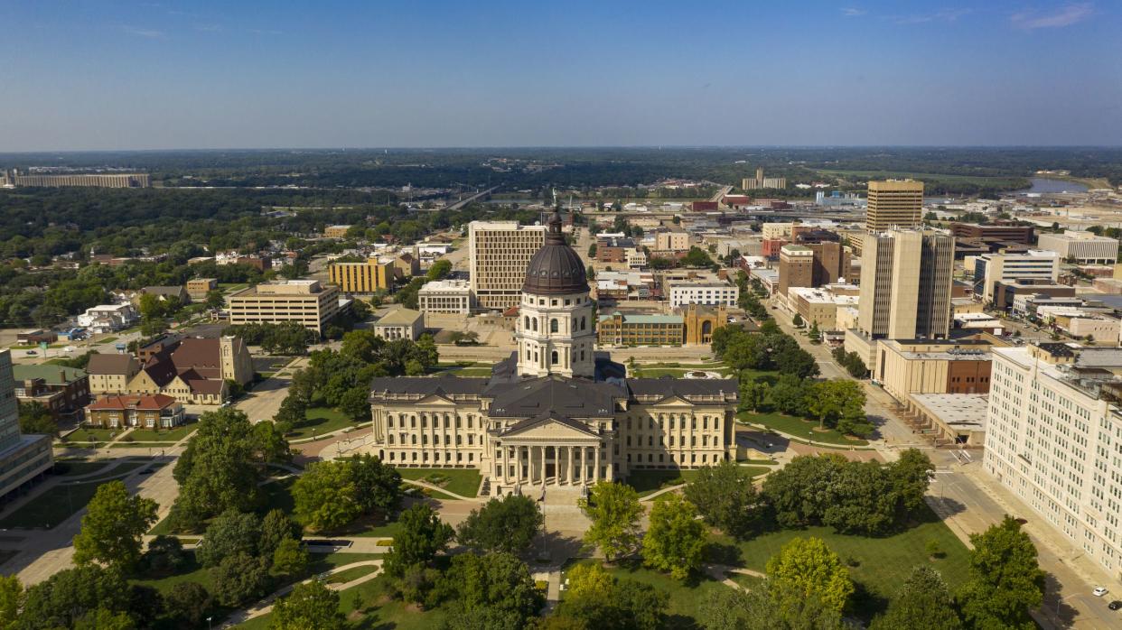 The copper dome shines in the urban area at the capitol building of Topeka Kansas