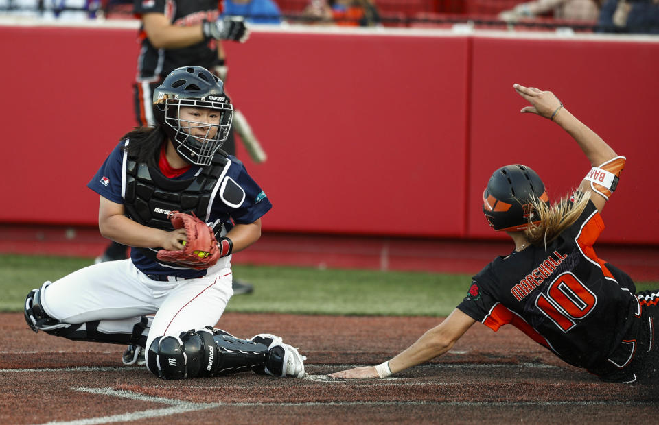 Sammy Marshall of Chicago Bandits scores a run ahead of the tag from Xu Junyi of Beijing Shougang Eagles during a National Pro Fastpitch League softball game. (Xinhua/Joel Lerner via Getty Images)