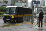 A prison van arrives as a police officer stands guard for Tong Ying-kit's arrival at the Hong Kong High Court in Hong Kong Friday, July 30, 2021. Tong was convicted Tuesday of inciting secession and terrorism for driving his motorcycle into a group of police officers during a July 1, 2020, pro-democracy rally while carrying a flag bearing the banned slogan, "Liberate Hong Kong, revolution of our times." Tong, 24, will be sentenced Friday, the court announced. (AP Photo/Vincent Yu)