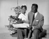 <p>Natalie Cole gets into the holiday spirit by singing carols with her famous father, musician Nat King Cole. The two posted up in front of the tree in 1970.</p>