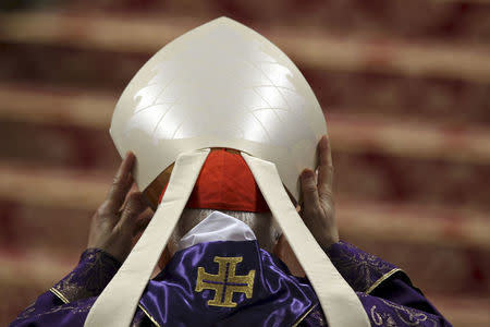 A Cardinal lifts his hat as Pope Francis leads the Ash Wednesday mass, in St. Peter's Basilica at the Vatican, in this February 10, 2016 file photo. REUTERS/Alessandro Bianchi/Files