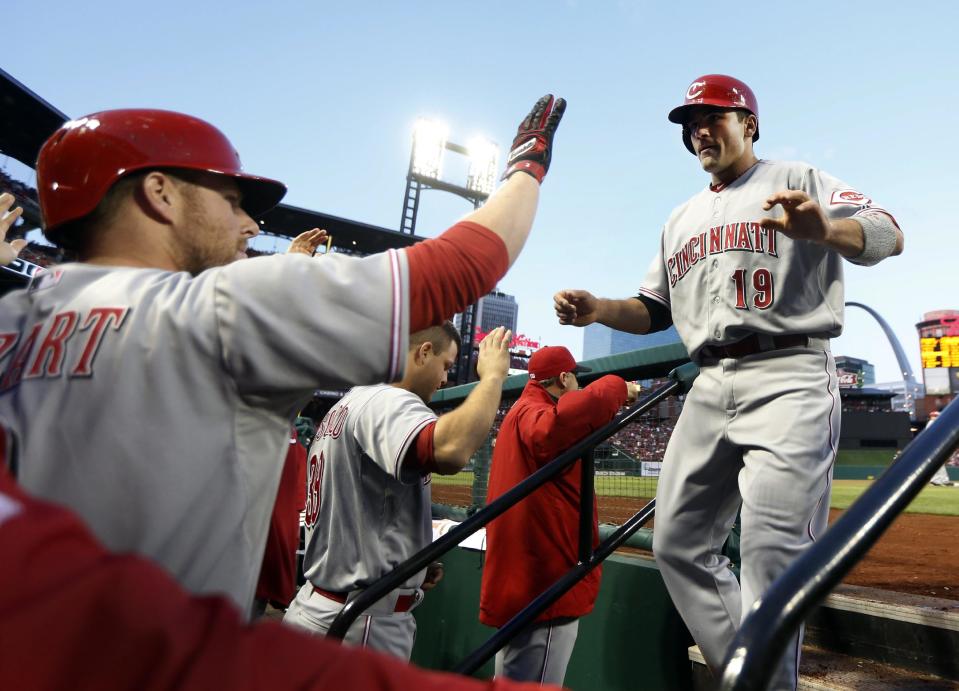 Cincinnati Reds' Joey Votto, right, is congratulated by teammate Zack Cozart, left, after scoring on a two-run triple by Jay Bruce during the first inning of a baseball game against the St. Louis Cardinals on Tuesday, April 8, 2014, in St. Louis. (AP Photo/Jeff Roberson)