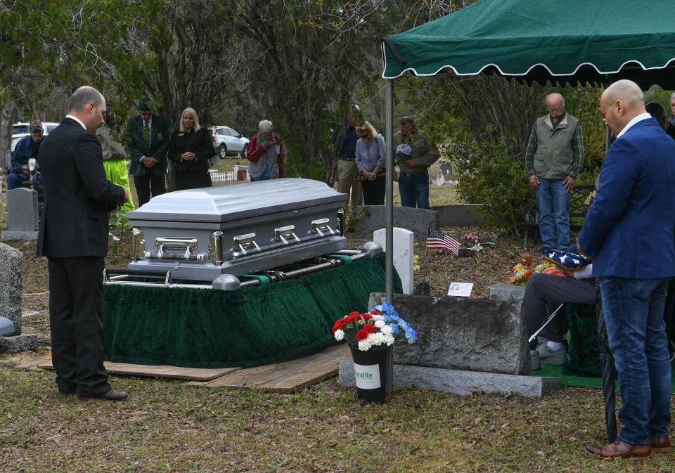 Dustin Tribble (left) of the First Missionary Baptist Church in Yeehaw, leads a prayer for the attendees of the graveside service for Robert Lee Hurst at the Winter Beach Cemetery on Saturday, Feb. 17, 2024, in Vero Beach.