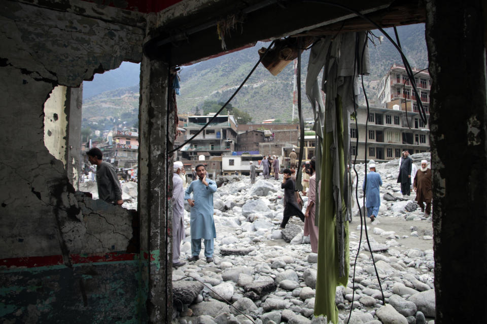 People salvage usable items from a damaged hotel after flooding in the town of Bahrain, Pakistan, Tuesday, Aug. 30, 2022. The United Nations and Pakistan issued an appeal Tuesday for $160 million in emergency funding to help millions affected by record-breaking floods that have killed more than 1,150 people since mid-June. (AP Photo/Naveed Ali)