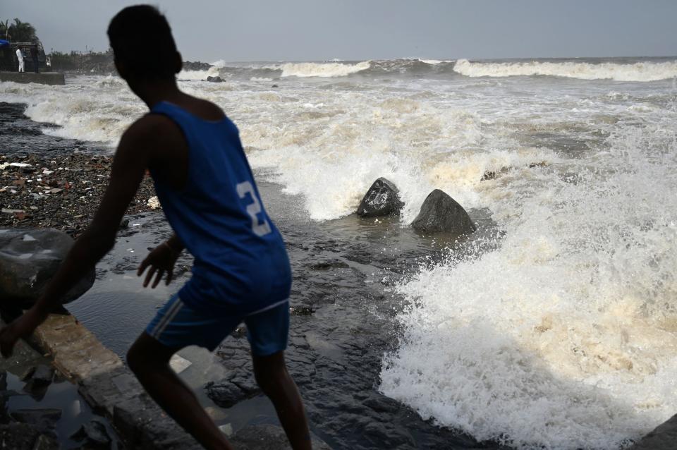 A boy moves away from the seafront as high waves hit the coast in Mumbai, India, June 13, 2023, as Cyclone Biparjoy makes its way across the Arabian Sea toward the coastlines of India and Pakistan. / Credit: PUNIT PARANJPE/AFP/Getty