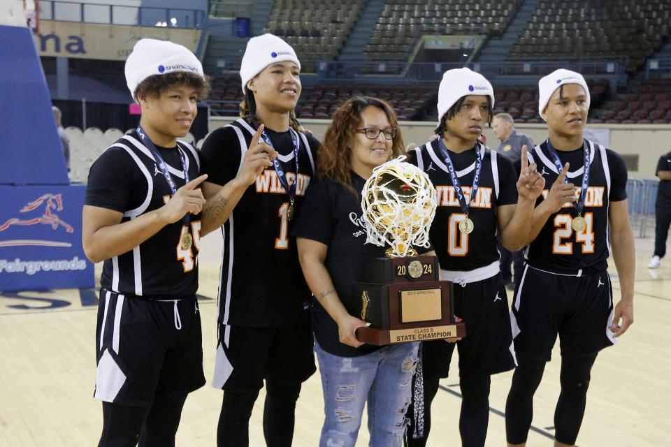Wilson (Henryetta) players and brothers from left, Charles Shelburn, Ke'shon Shelburn, Zion Shelburn and Za'brien Shelburn pose for a picture with their mother, Natasha Francis, after winning the Class B boys state basketball championship on Saturday.