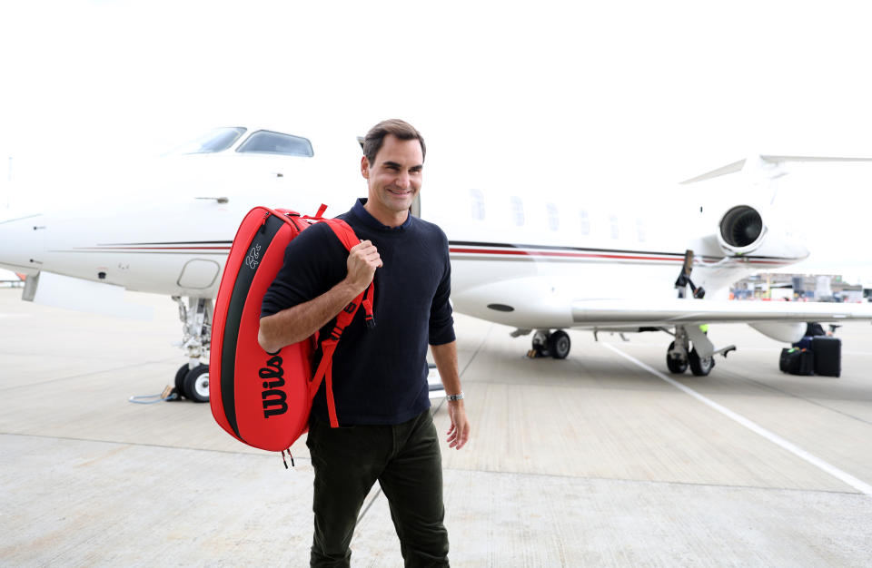 Roger Federer (pictured) carries his bag after arriving in London ahead of the Laver Cup.