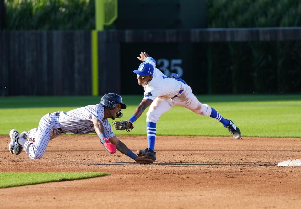 Alerick Soularie of Cedar Rapids tries to slide back into second base as Tyler Tolbert of the River Bandits tries to make the tag during a minor league game at the Field of Dreams in Dyersville, Tuesday, Aug. 9, 2022.