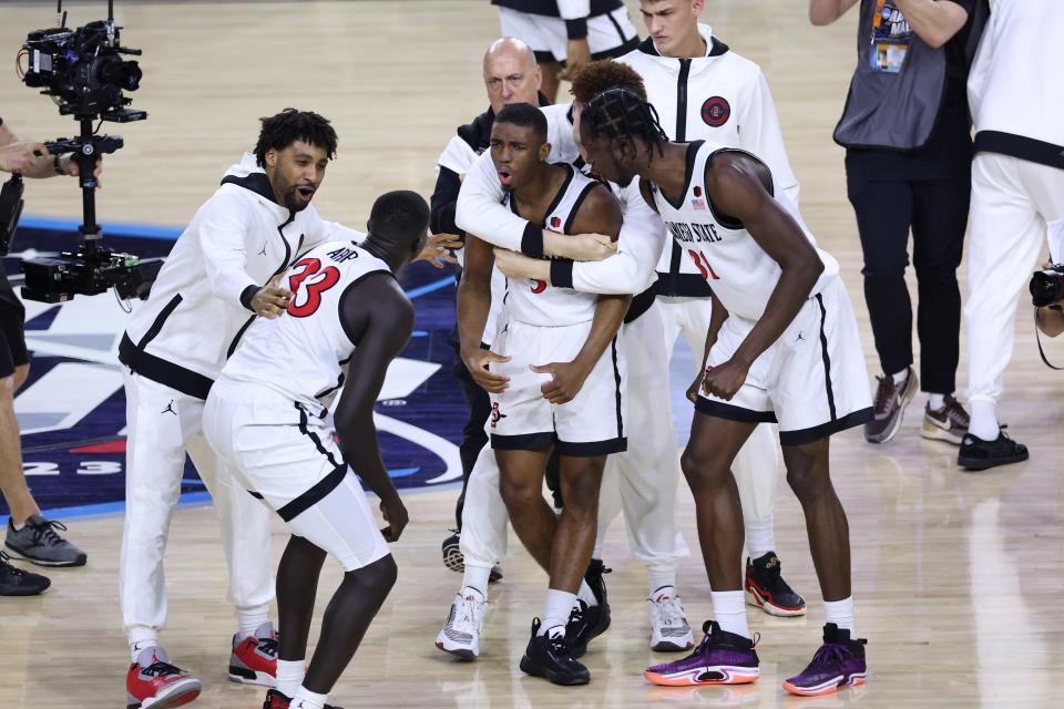 San Diego State guard Lamont Butler (5) celebrates with teammates after scoring the game-winning shot against Florida Atlantic during the national semifinals of the 2023 NCAA men's tournament at NRG Stadium.