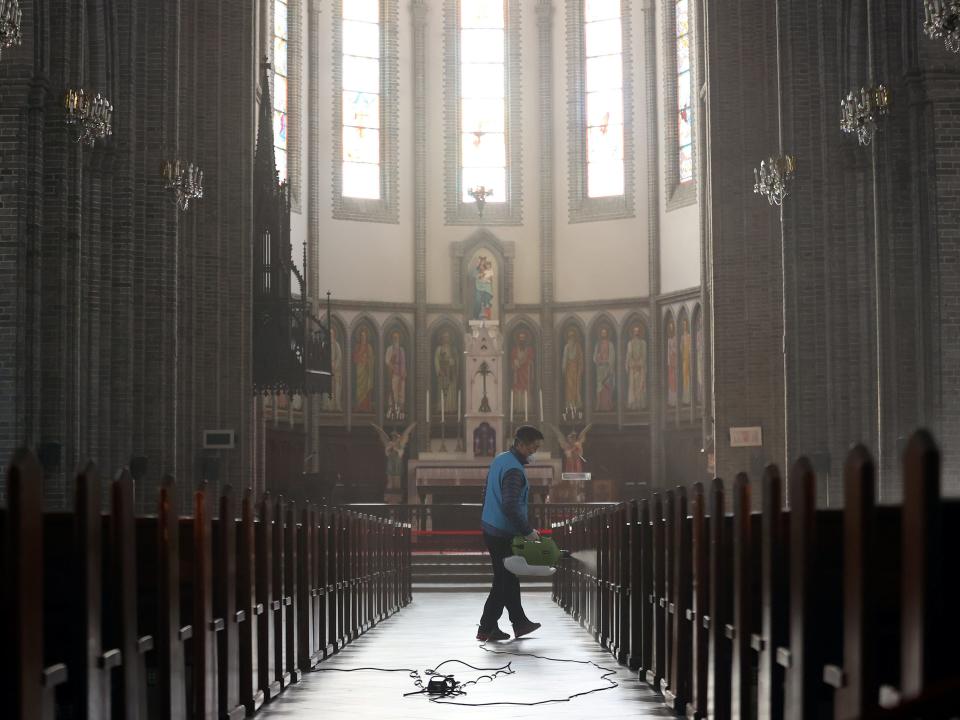 An employee from a disinfection service company sanitizes Myeongdong Catholic Cathedral in Seoul, South Korea, February 26, 2020. Yonhap via REUTERS.JPG