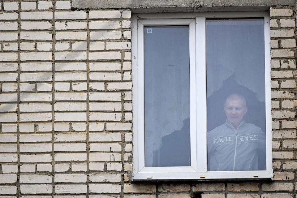 Alexei Moskalyov looks out through the window of his flat after he was placed under house for repeating Ukraine posts discrediting the Russian army (AFP via Getty Images)