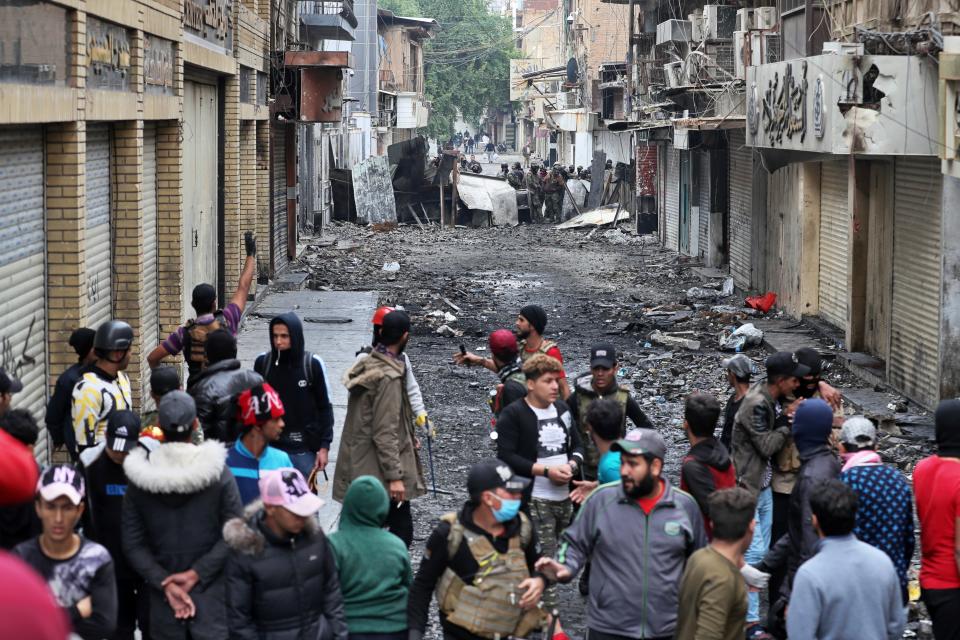 Anti-government protesters and security forces face off on River Street during ongoing protests in Baghdad, Iraq, Tuesday, Dec. 3, 2019. At least 400 people have died since the leaderless uprising shook Iraq on Oct. 1, with thousands of Iraqis taking to the streets in Baghdad and the predominantly Shiite southern Iraq decrying corruption, poor services, lack of jobs and calling for an end to the political system that was imposed after the 2003 U.S. invasion. (AP Photo/Khalid Mohammed)