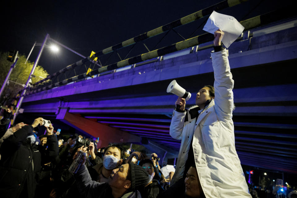 Muž drží biele listy papiera na protest proti obmedzeniam koronavírusovej choroby (COVID-19) po vigílii za obete požiaru v Urumči, keďže epidémie COVID-19 pokračujú, v Pekingu, Čína, 28. novembra 2022. REUTERS/ Tomáš Peter