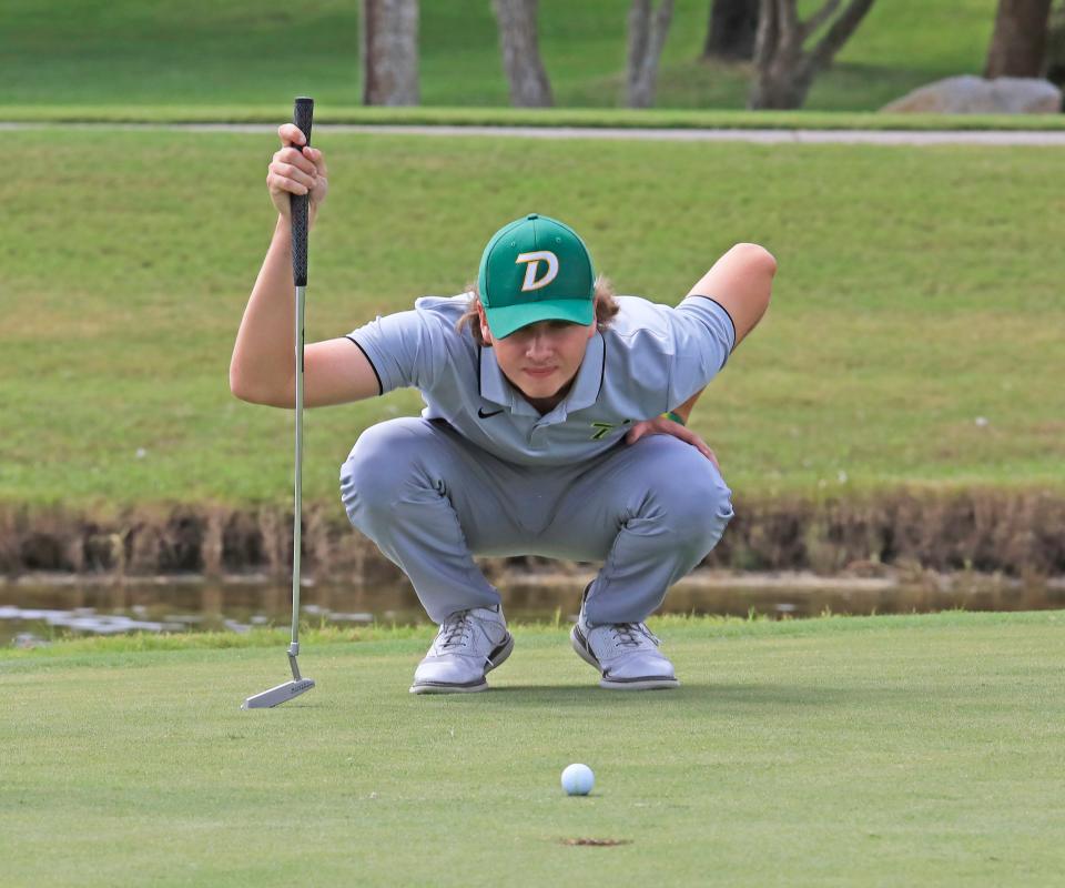 DeLand's Isak Coveney studies his line before putting during the Volusia/Flagler Boys Championship on Monday, Oct. 9, 2023 at Crane Lakes in Port Orange.
